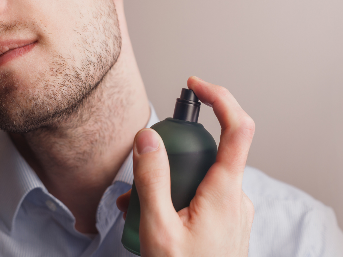 Pria menyemprotkan parfum ke lehernya untuk tampil wangi sepanjang hari dengan parfum budget berkualitas.