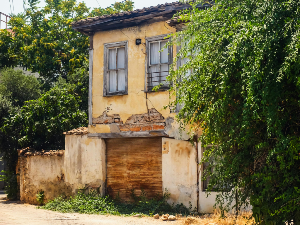 Bangunan kosong yang tampak dari bagian depan terlihat angker dengan dinding kusam dan suasana sepi