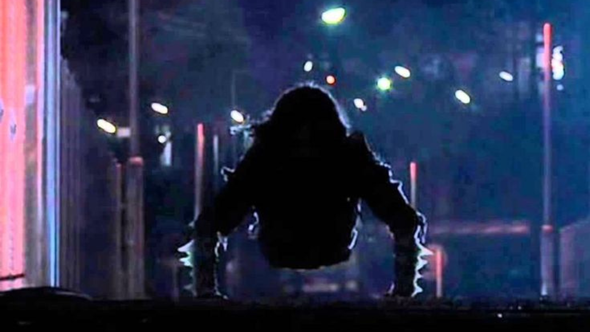 Sosok menyeramkan mirip hantu Teke-Teke merangkak cepat di jalan gelap pada malam hari, dengan siluet tubuh bagian atas dan lampu kota yang redup di latar belakang.