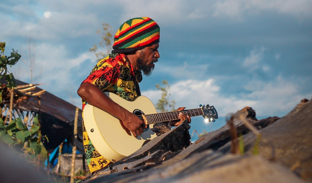Musisi Papua memainkan gitar di alam terbuka sebagai bagian dari budaya musik Indonesia Timur
