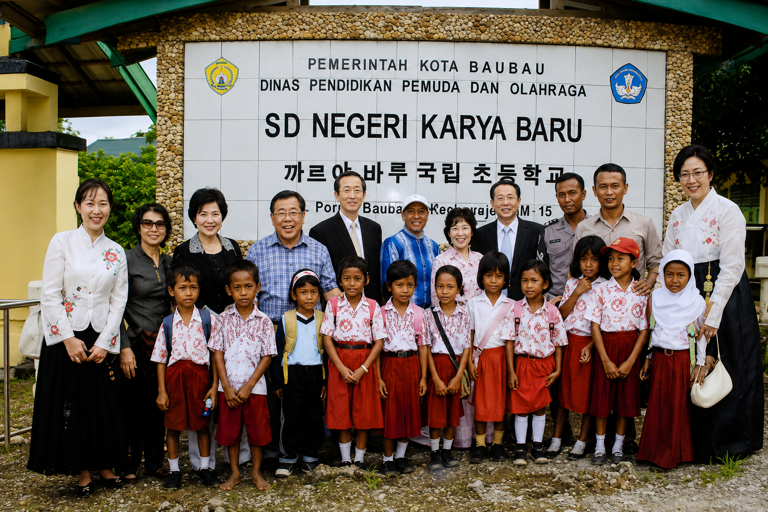 Siswa SD Negeri Karya Baru berfoto di depan sekolah yang menggunakan tulisan Latin dan Hangeul pada papan namanya.