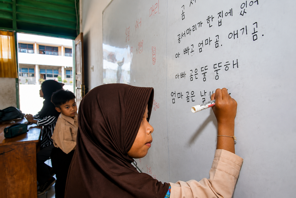 Siswi menulis aksara Hangeul di papan tulis dalam kegiatan pembelajaran di sekolah.