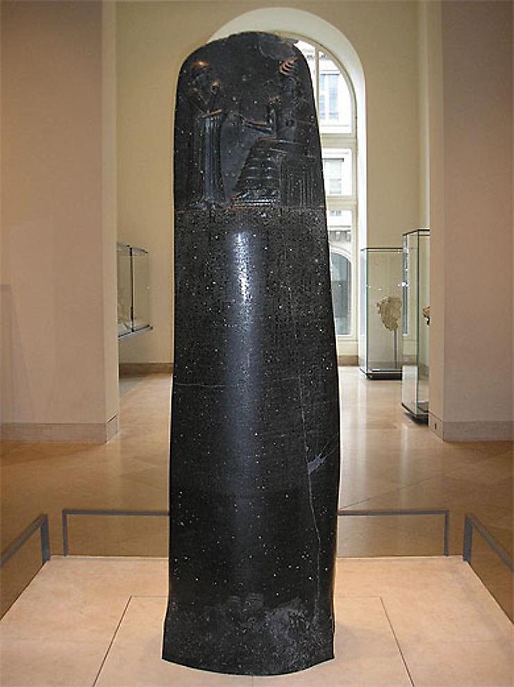 Prasasti Hammurabi Code berwarna hitam yang dipamerkan di museum, berisi kumpulan hukum kuno dari peradaban Babilonia.